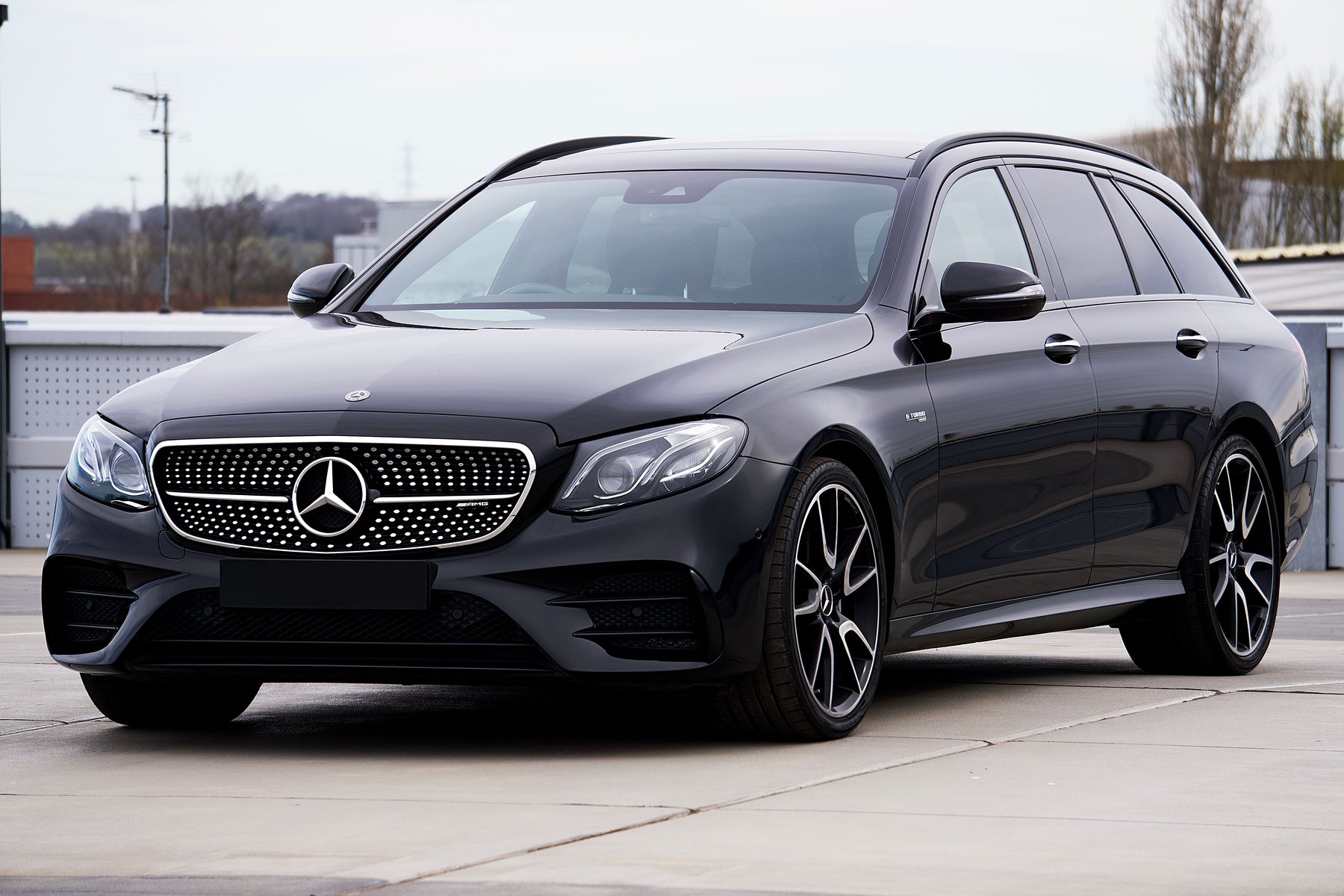 Black Mercedes E-Class Estate parked on an open car park deck