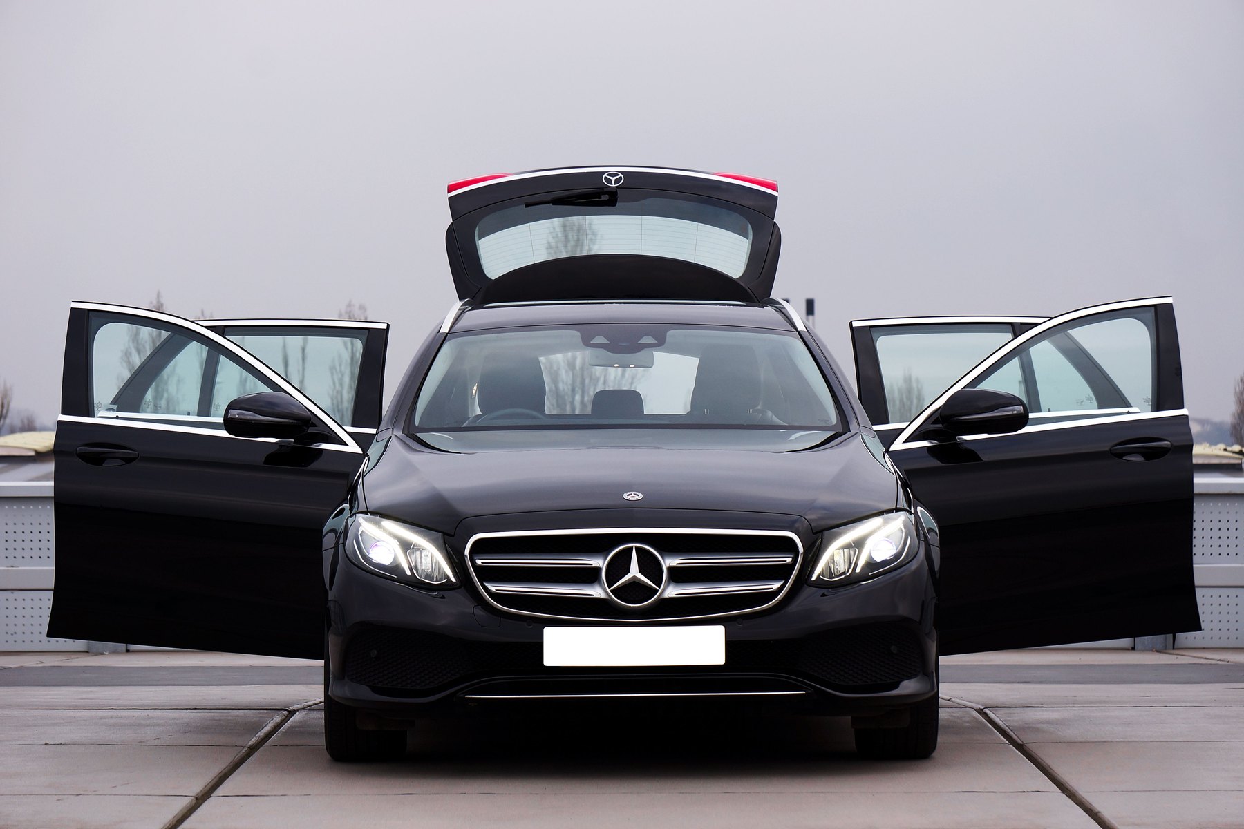 Black Mercedes E-Class saloon with its doors and boot open